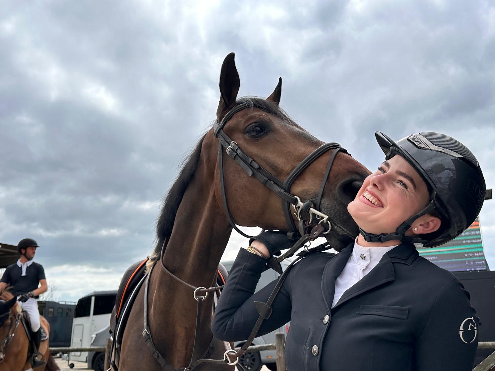 Een ruiter tussen meerdere paarden in de wei
